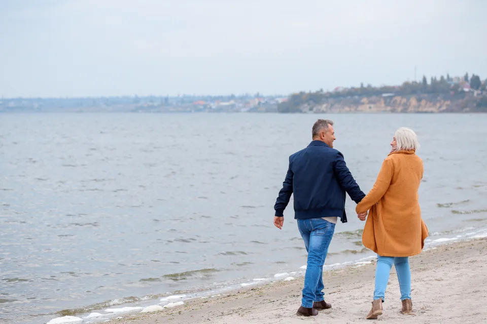 Older couple walking together along a beach