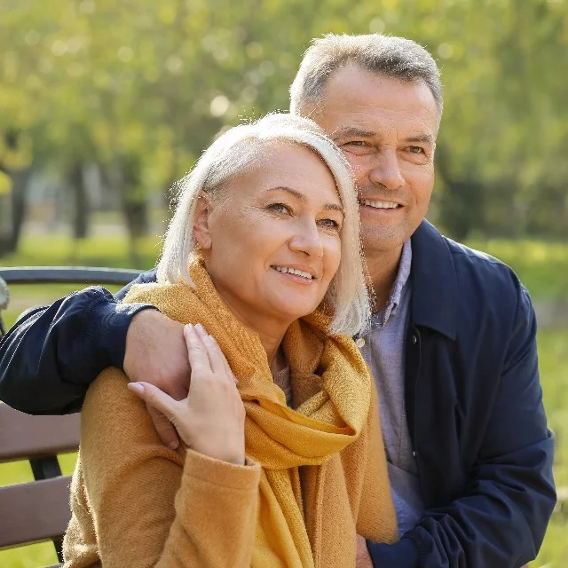 Older couple sitting together on a park bench